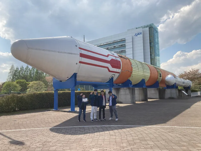 Group photo in front of the H-II rocket at Tsukuba Space Center / April 2024